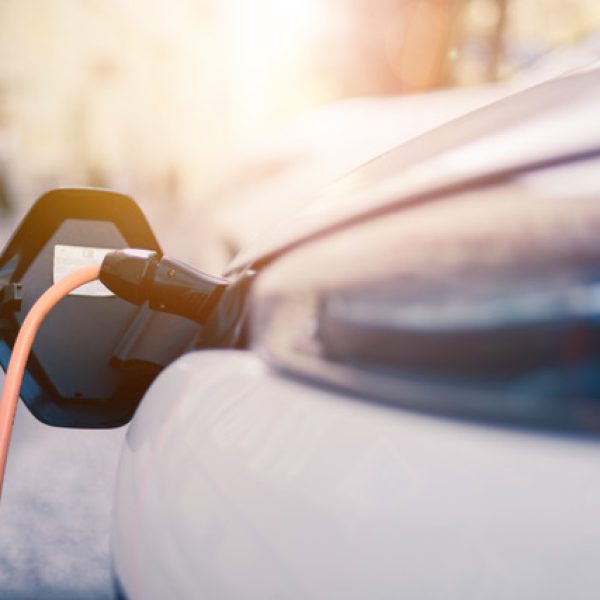 Electric car recharging with charge cable and plug leading to charge point.